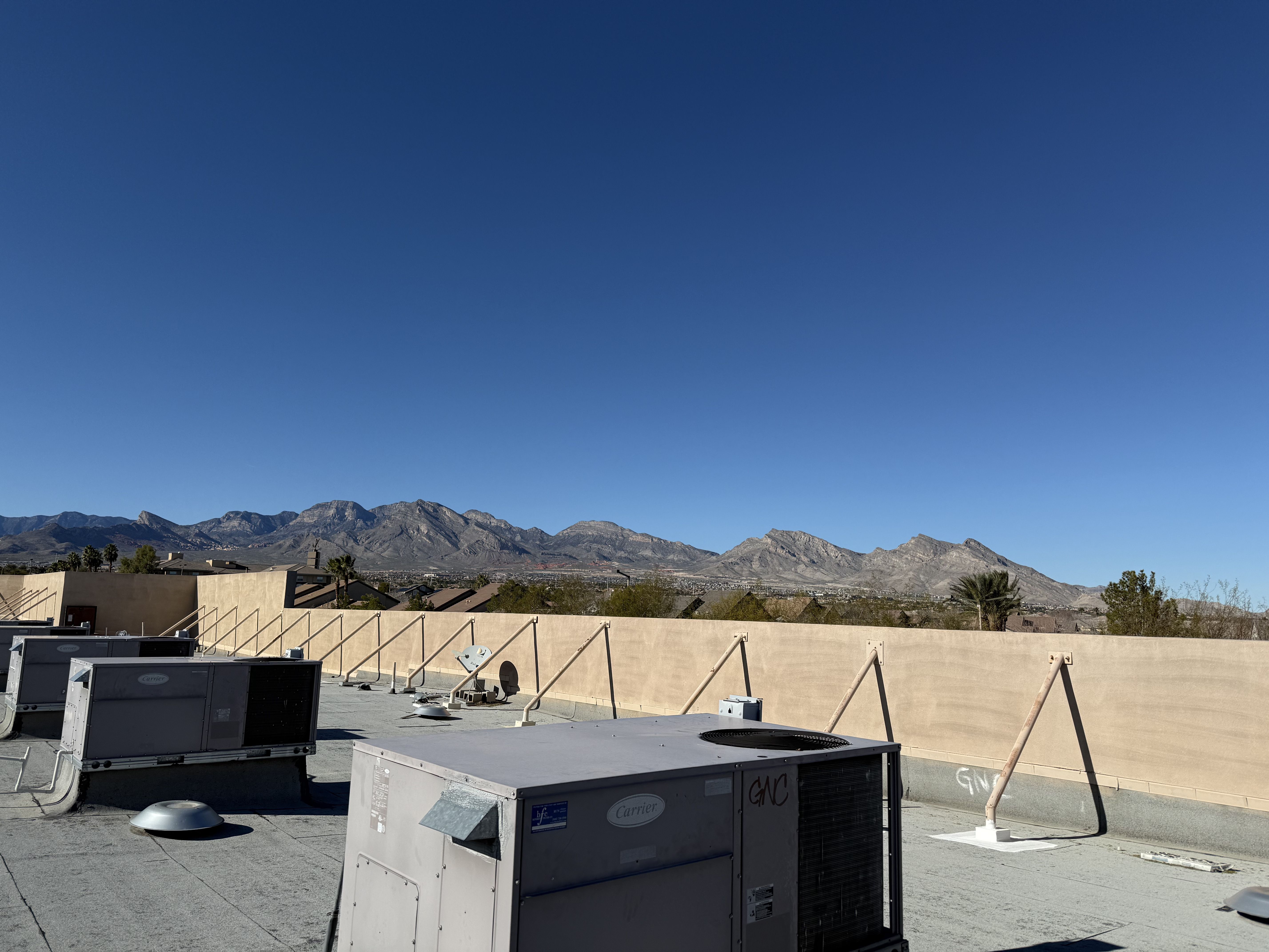 Rooftop Carrier commercial HVAC units on a Las Vegas, NV building with the Spring Mountains in the background
