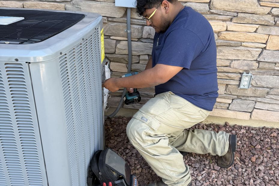 Constant Air Balancing technician servicing a residential outdoor HVAC condenser unit at a Las Vegas, NV home
