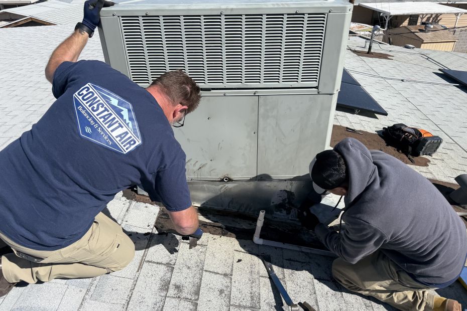 Two Constant Air Balancing technicians working together at a commercial rooftop package unit in Las Vegas, NV