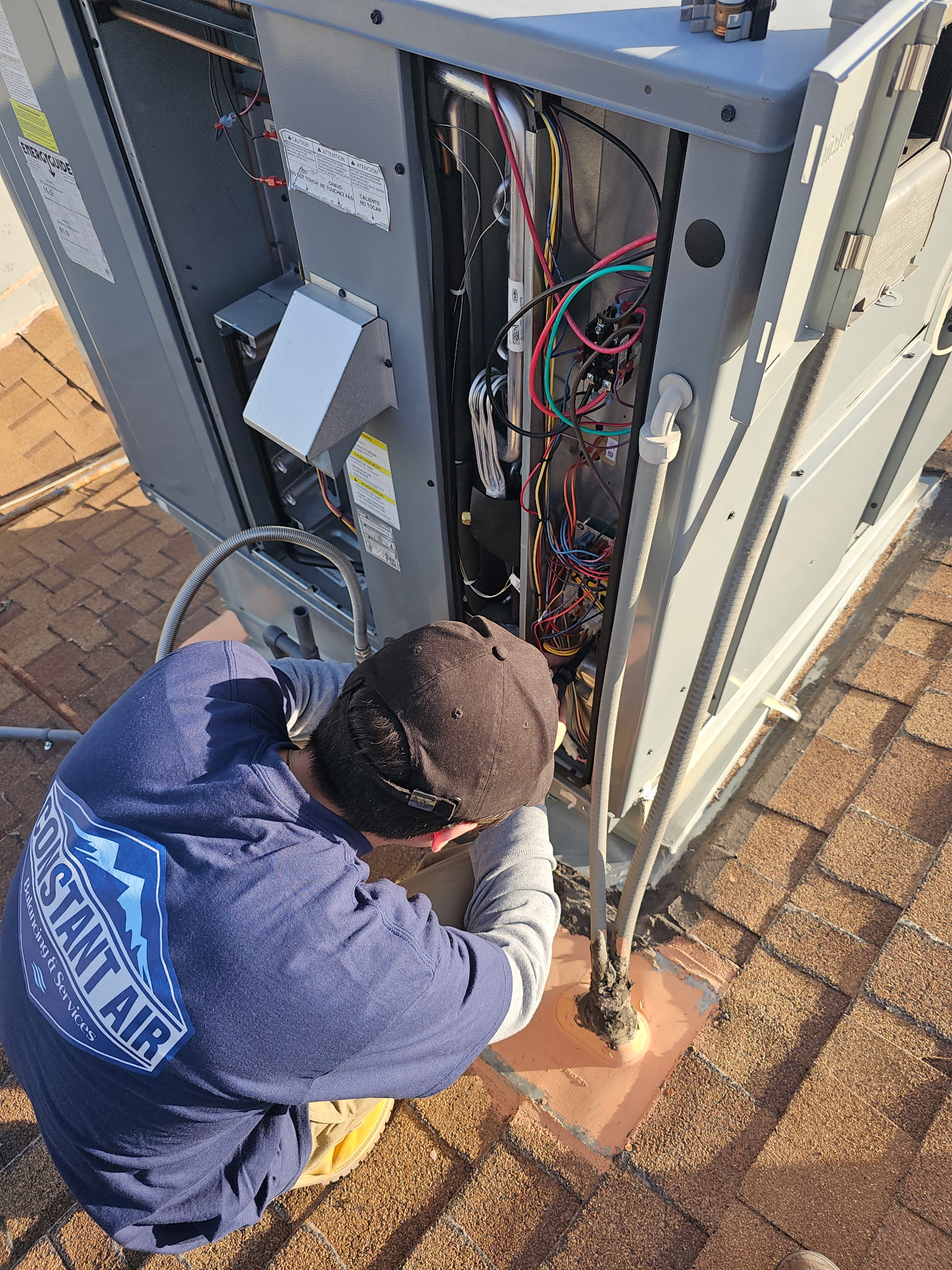 Constant Air Balancing technician diagnosing an outdoor HVAC condenser with exposed wiring in Las Vegas, NV