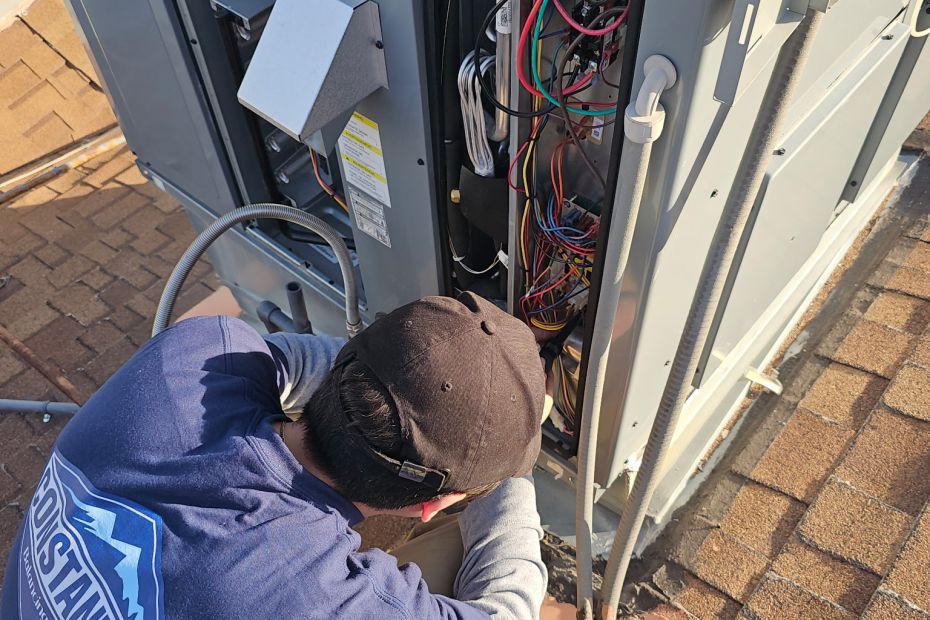 Constant Air Balancing technician diagnosing an outdoor HVAC condenser with exposed wiring in Las Vegas, NV