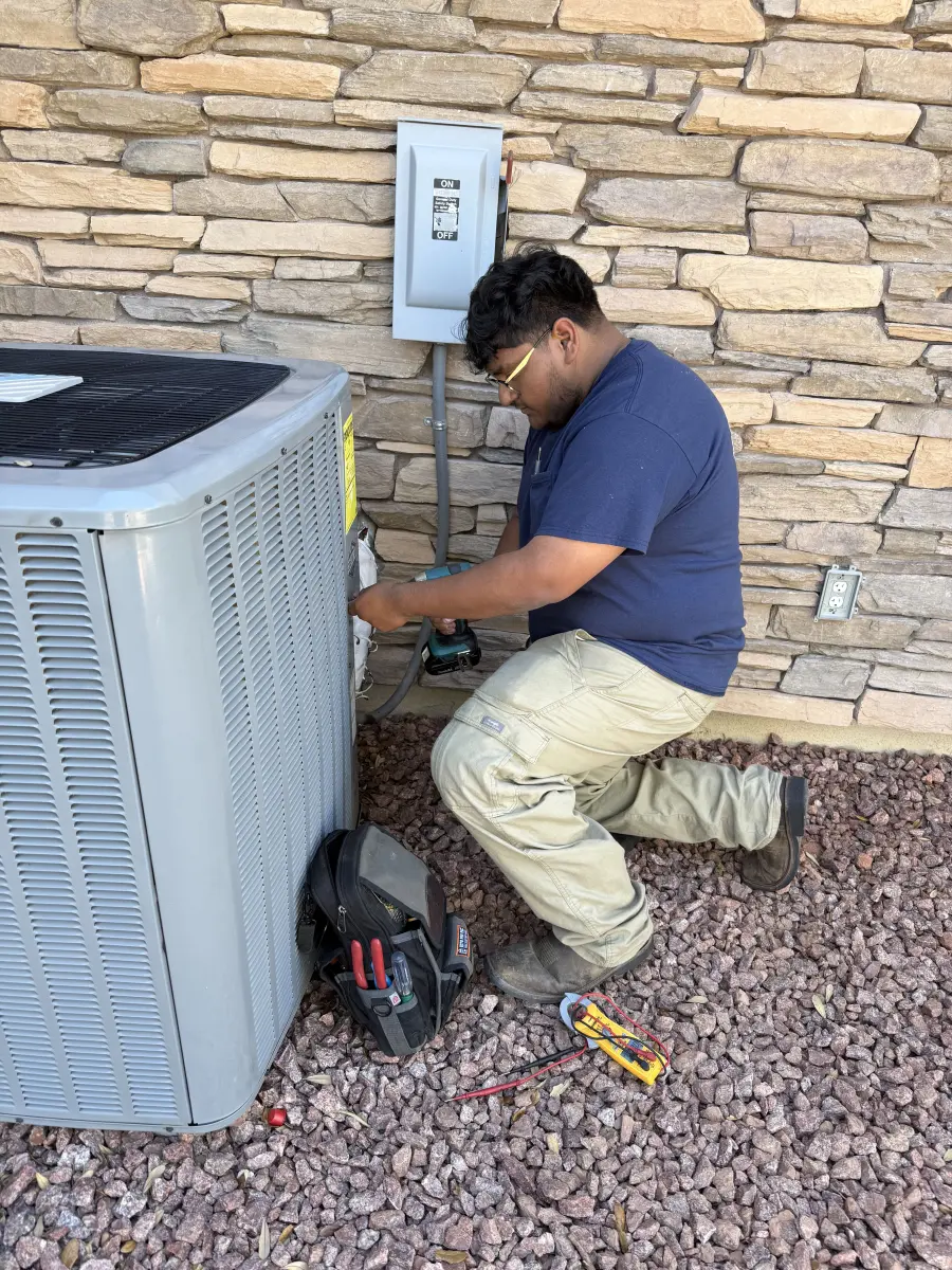 HVAC technician servicing outdoor AC unit in Las Vegas
